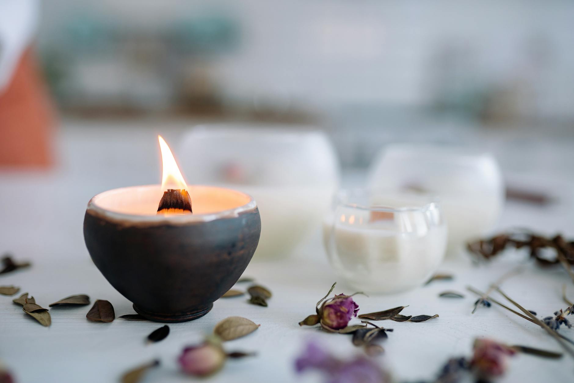 a burning candle on ceramic container