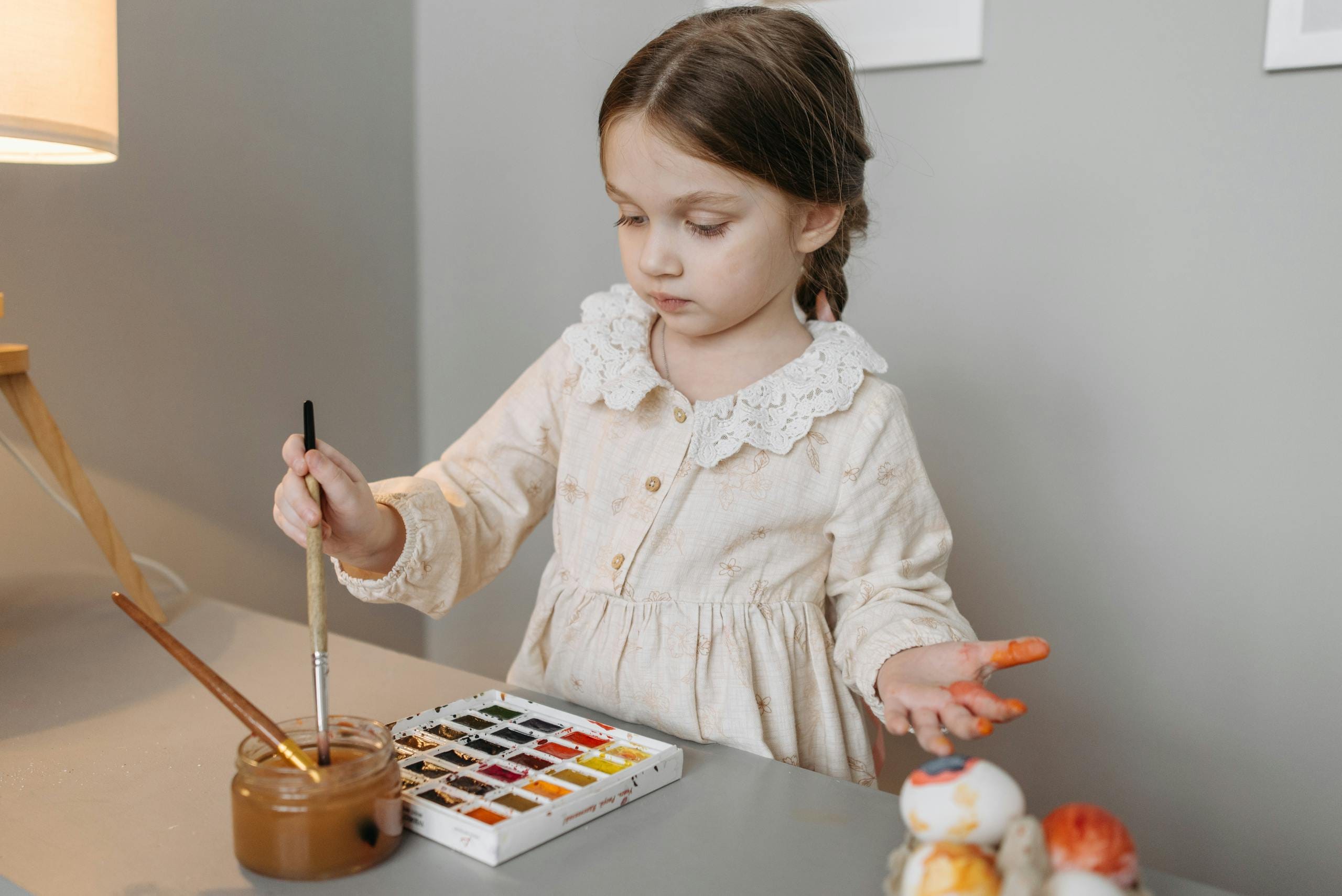 Young girl painting in art therapy with watercolors and a brush.